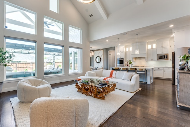 living room featuring dark wood-type flooring, beam ceiling, and high vaulted ceiling