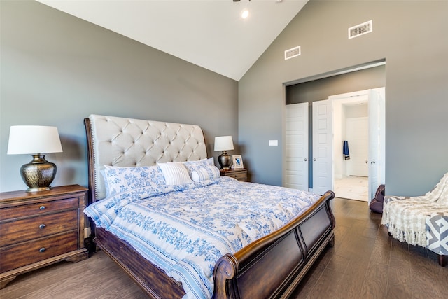 bedroom with dark wood-type flooring, high vaulted ceiling, and ensuite bath