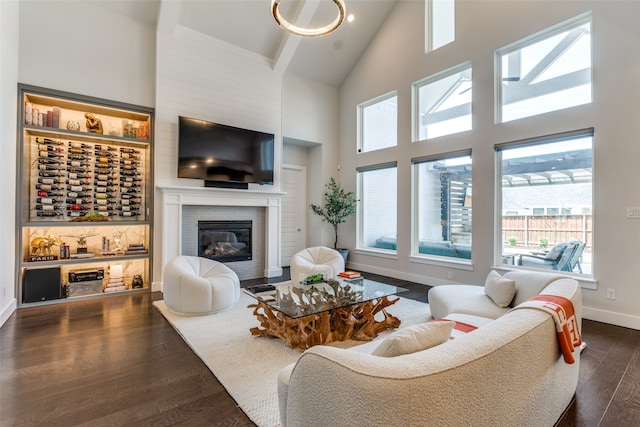 living room featuring dark hardwood / wood-style floors, high vaulted ceiling, and a brick fireplace