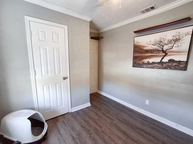 bedroom featuring a textured ceiling, dark hardwood / wood-style floors, ceiling fan, and crown molding