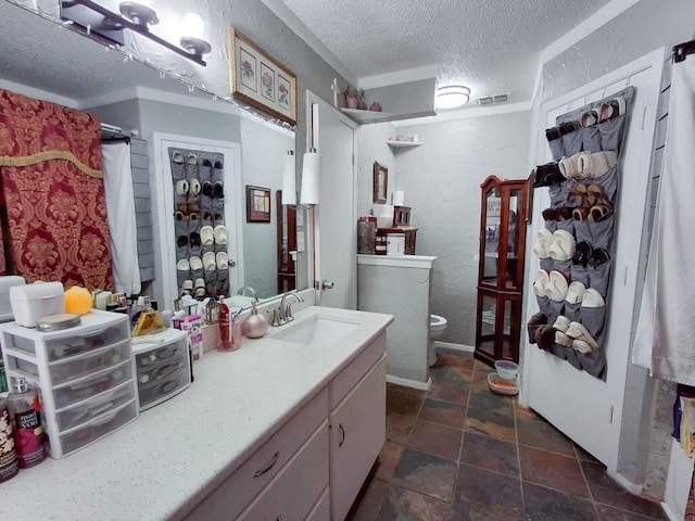 bathroom featuring vanity, a textured ceiling, and toilet