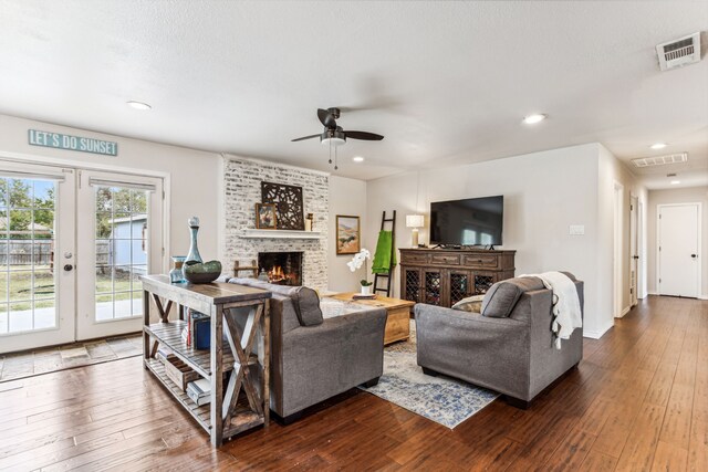 living room with ceiling fan, a textured ceiling, and wood-type flooring