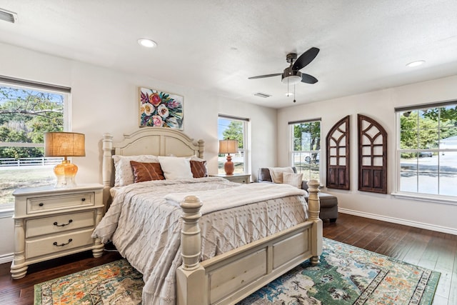 bedroom featuring ceiling fan, a textured ceiling, and dark hardwood / wood-style flooring