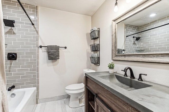 full bathroom with vanity, toilet, wood-type flooring, and tiled shower / bath combo