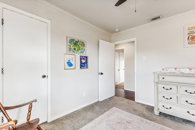 carpeted bedroom featuring crown molding and ceiling fan