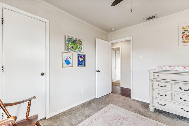 carpeted bedroom with crown molding and ceiling fan