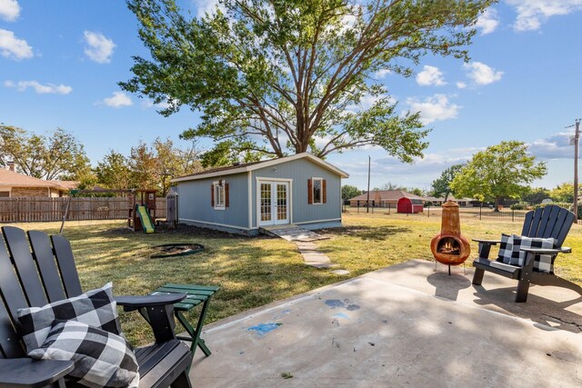 view of patio / terrace featuring an outbuilding, french doors, and a playground