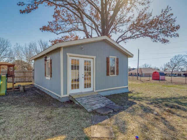 view of patio with a playground, an outbuilding, and french doors