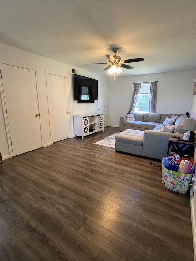 living room with ceiling fan and dark hardwood / wood-style flooring