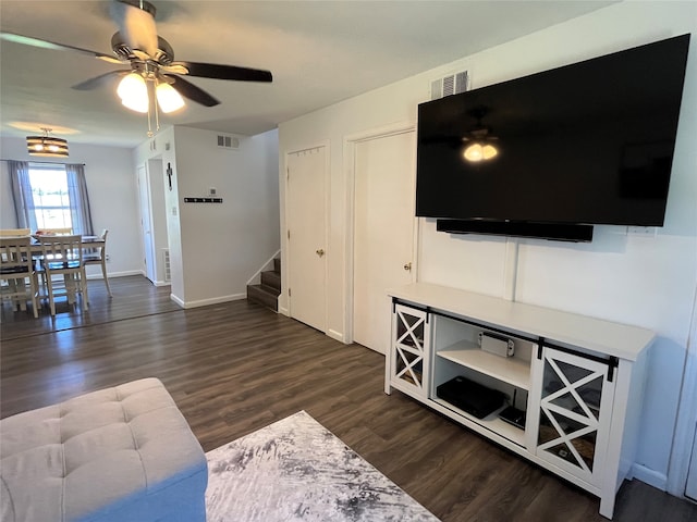 living room featuring dark wood-type flooring and ceiling fan