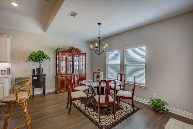 dining space with a notable chandelier and dark hardwood / wood-style floors