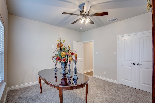 interior space featuring light carpet and ceiling fan