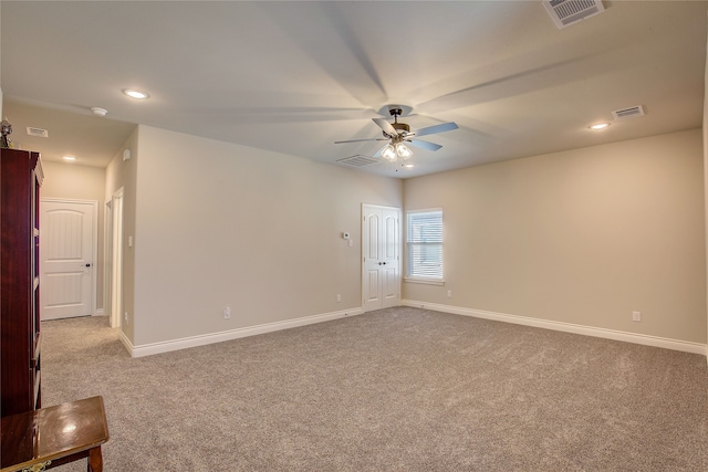 carpeted spare room featuring ceiling fan