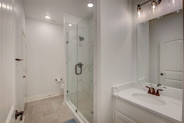 bathroom featuring vanity, tile patterned flooring, toilet, and walk in shower