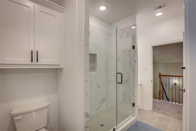 bathroom featuring a shower with door, toilet, and tile patterned flooring