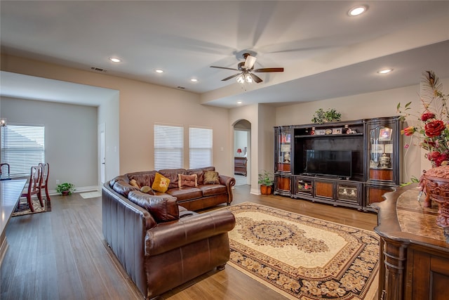 living room featuring wood-type flooring, plenty of natural light, and ceiling fan