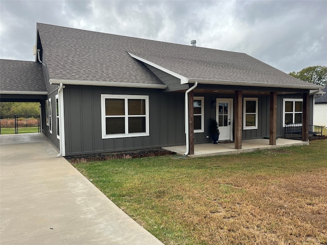 rear view of house featuring covered porch and a yard