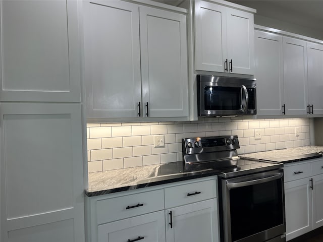 kitchen featuring white cabinetry, stainless steel appliances, and backsplash