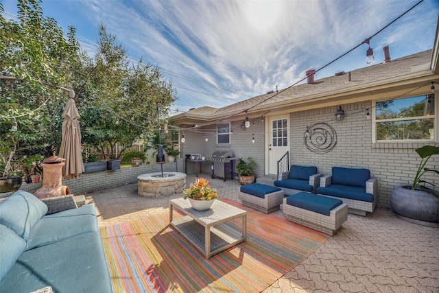 view of patio / terrace with grilling area and an outdoor living space with a fire pit