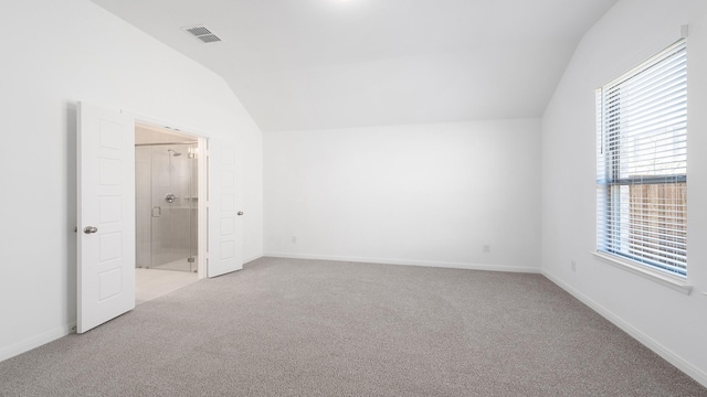 unfurnished bedroom with lofted ceiling, ensuite bath, and light carpet