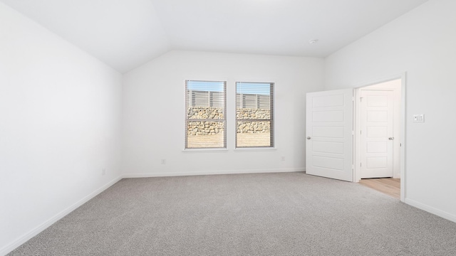 interior space with light colored carpet and lofted ceiling