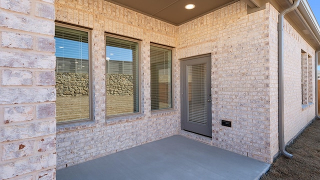 view of exterior entry with a patio