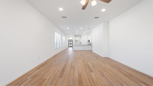 unfurnished living room featuring ceiling fan and light wood-type flooring