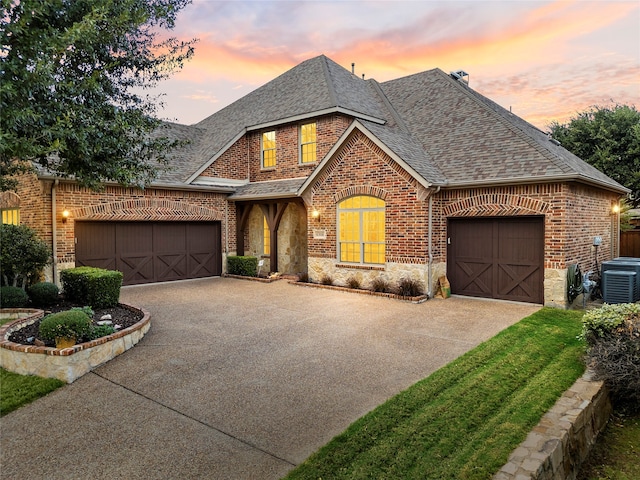 view of front of home with a garage and central air condition unit