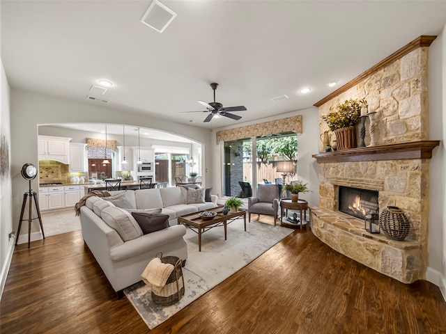 living room featuring ceiling fan, a fireplace, and hardwood / wood-style floors