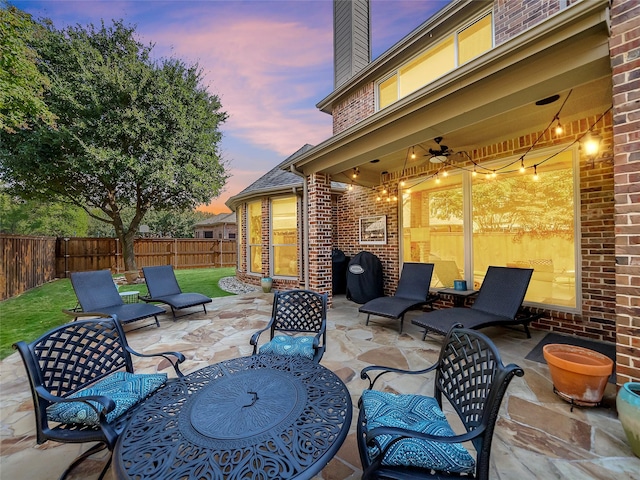 patio terrace at dusk featuring ceiling fan