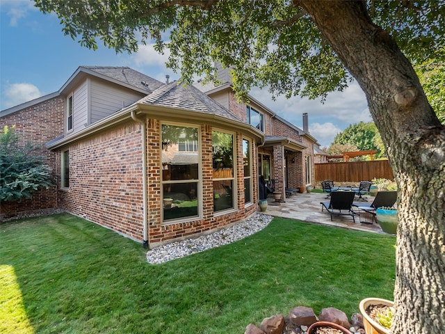 rear view of house with a patio and a yard