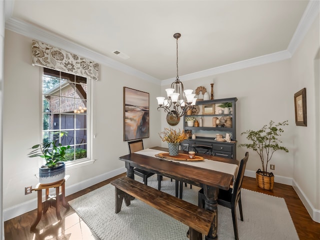 dining space with dark wood-type flooring, a notable chandelier, a wealth of natural light, and crown molding