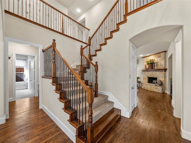 stairway with hardwood / wood-style flooring and a fireplace