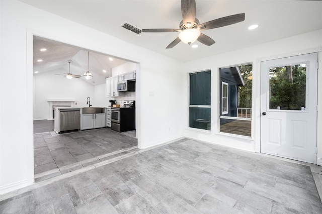 kitchen with appliances with stainless steel finishes, ceiling fan, sink, white cabinets, and lofted ceiling