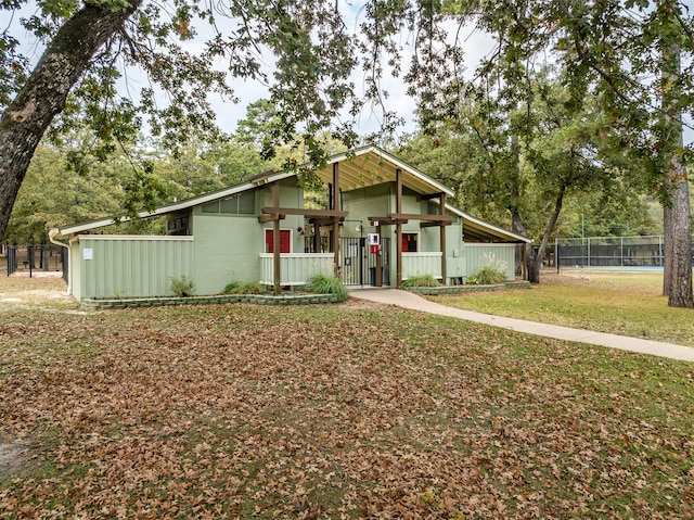 mid-century home with a front lawn and fence