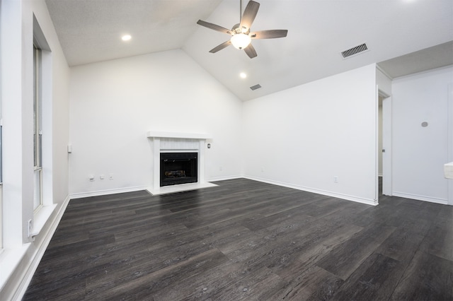 unfurnished living room with visible vents, a ceiling fan, lofted ceiling, dark wood-style floors, and a fireplace with flush hearth