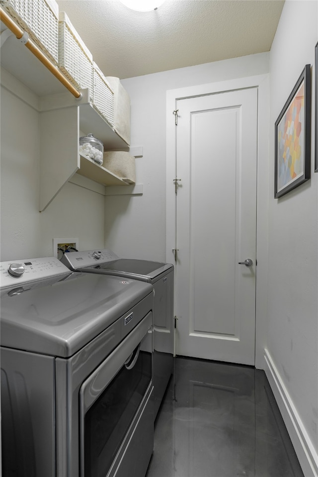 laundry area with a textured ceiling and washing machine and clothes dryer