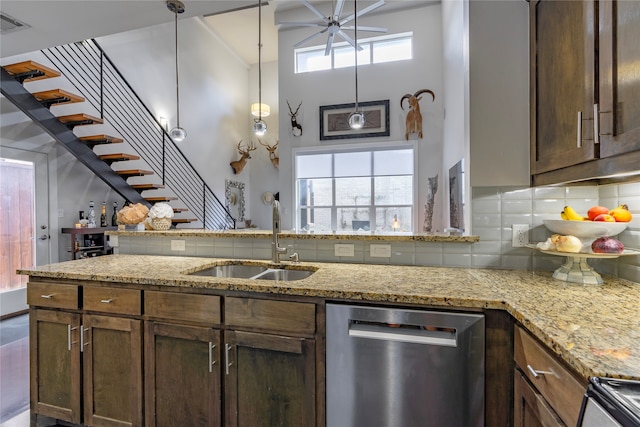 kitchen with sink, appliances with stainless steel finishes, light stone counters, and plenty of natural light