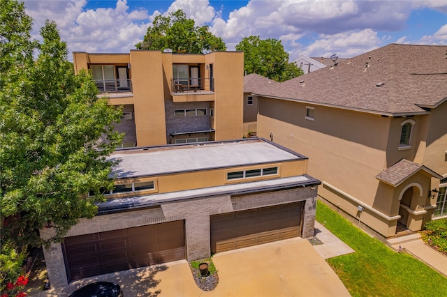 view of front of property featuring a balcony and a garage