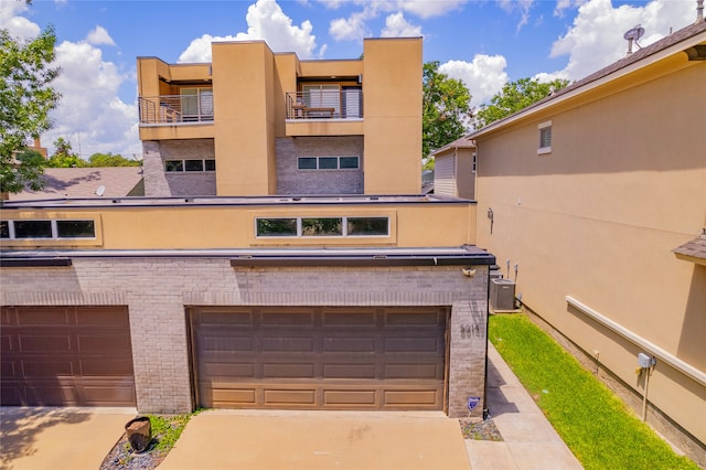 view of front of property with cooling unit, a balcony, and a garage