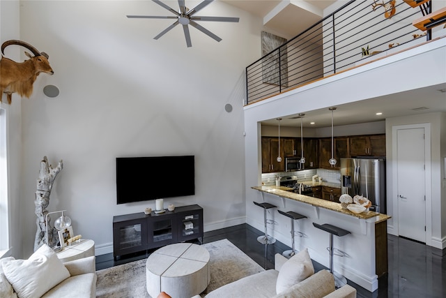 living room featuring a high ceiling and ceiling fan