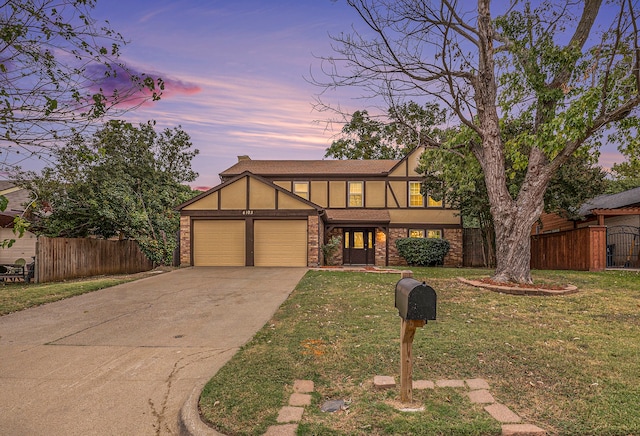 tudor house featuring a lawn and a garage