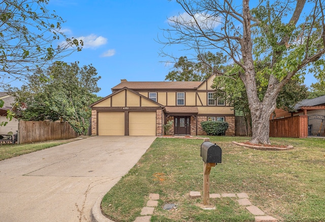 tudor home featuring a garage and a front lawn