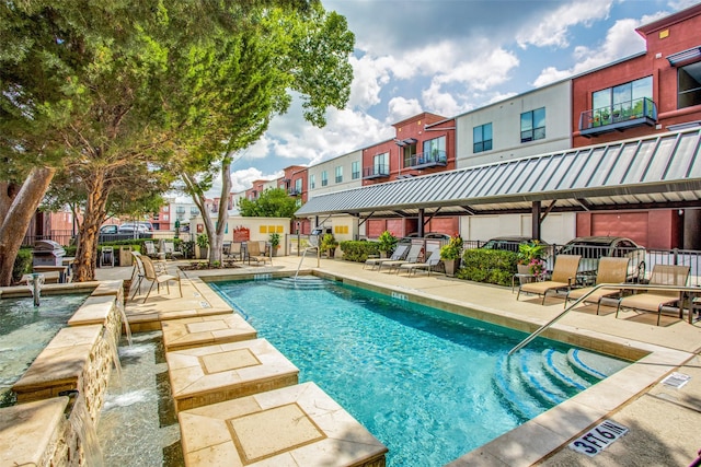 view of pool featuring pool water feature and a patio area