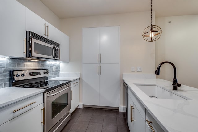 kitchen with decorative backsplash, stainless steel appliances, sink, decorative light fixtures, and white cabinets