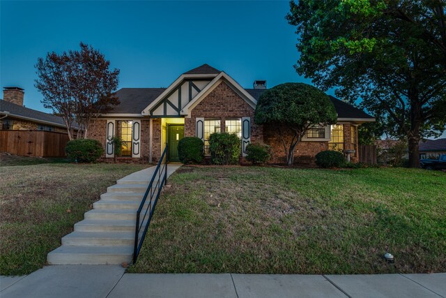 tudor home featuring a yard