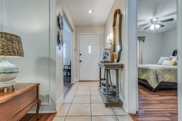 foyer entrance with light hardwood / wood-style floors and ceiling fan