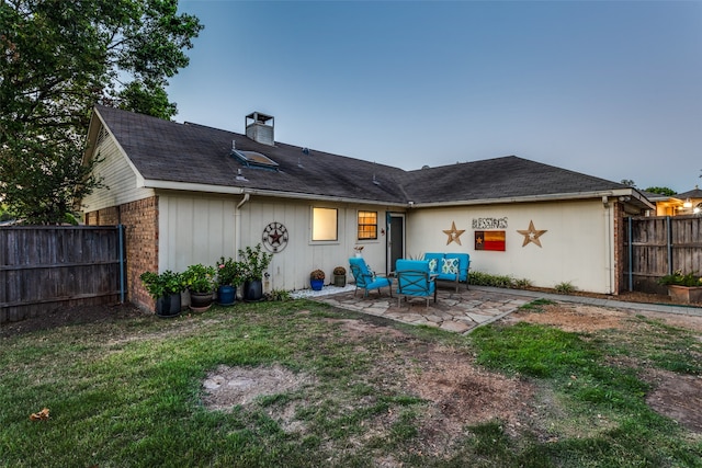 back of house featuring a patio and a yard