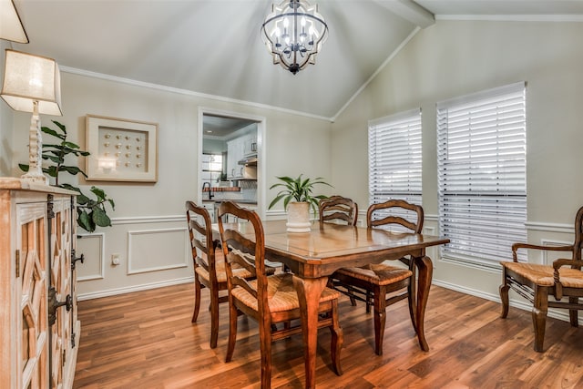 dining room with ornamental molding, lofted ceiling with beams, and dark hardwood / wood-style flooring