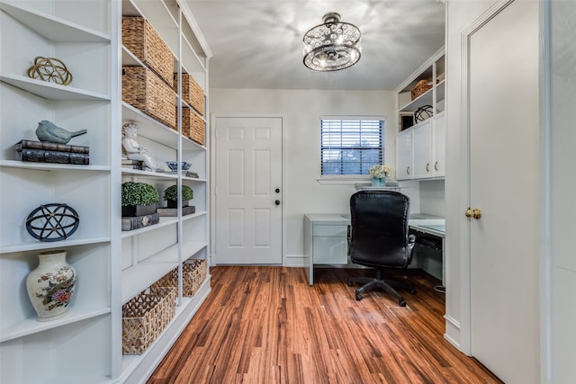 home office featuring built in desk, a chandelier, and dark hardwood / wood-style flooring